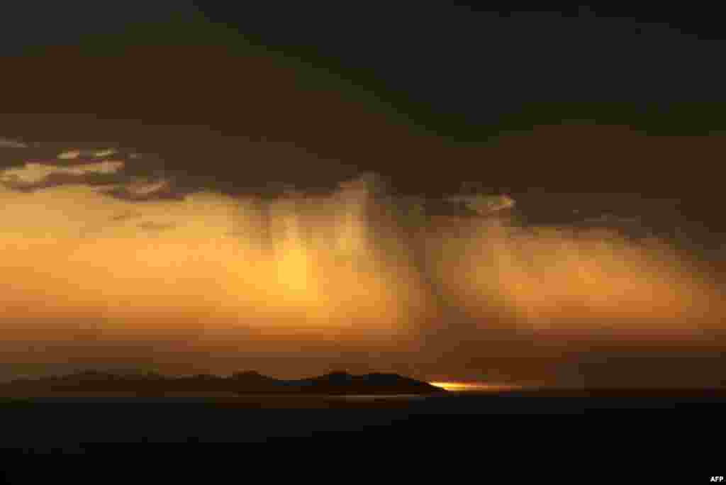 The sun rises behind a bank of cloud on the Greek island of Sifnos.