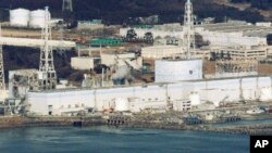 Reactors 1 to 4 (from R to L) of the Fukushima Daiichi nuclear power plant in Fukushima are seen in this picture taken more than 30km (18 miles) offshore from the site shortly before the start of the water-dropping operation, March 17, 2011