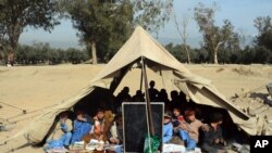 Afghan students attend a school class under a tent in Jalalabad, capital of Nangarhar province, Afghanistan, Dec. 16, 2015. 