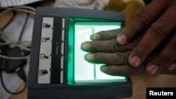 A villager goes through the process of a fingerprint scanner for the Unique Identification (UID) database system at an enrollment center at Merta district in the desert Indian state of Rajasthan, Feb. 22, 2013. 