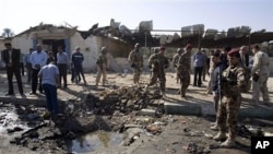 Iraqi security forces inspect the scene of a car bomb attack in Karbala, 50 miles (80 kilometers) south of Baghdad, 8 Nov. 2010.