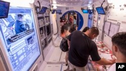 Pengunjung melakukan tur di dalam tiruan modul Stasiun Luar Angkasa Internasional (ISS) dalam program "Space Camp di Space & Rocket Center AS di Huntsville, Alabama, 13 Juli 2018. (Foto: dok). 