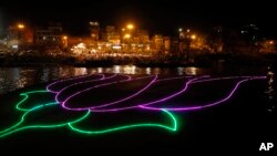 An illumination in the shape of a lotus, party symbol of the winning Bharatiya Janata Party, illuminates the River Ganges in Varanasi, in the northern Indian state of Uttar Pradesh, May 16, 2014.
