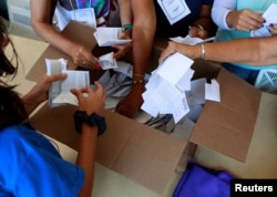 Opposition supporters count votes at a polling station after an unofficial plebiscite against President Nicolas Maduro's government and his plan to rewrite the constitution, in Caracas, Venezuela July 16, 2017.