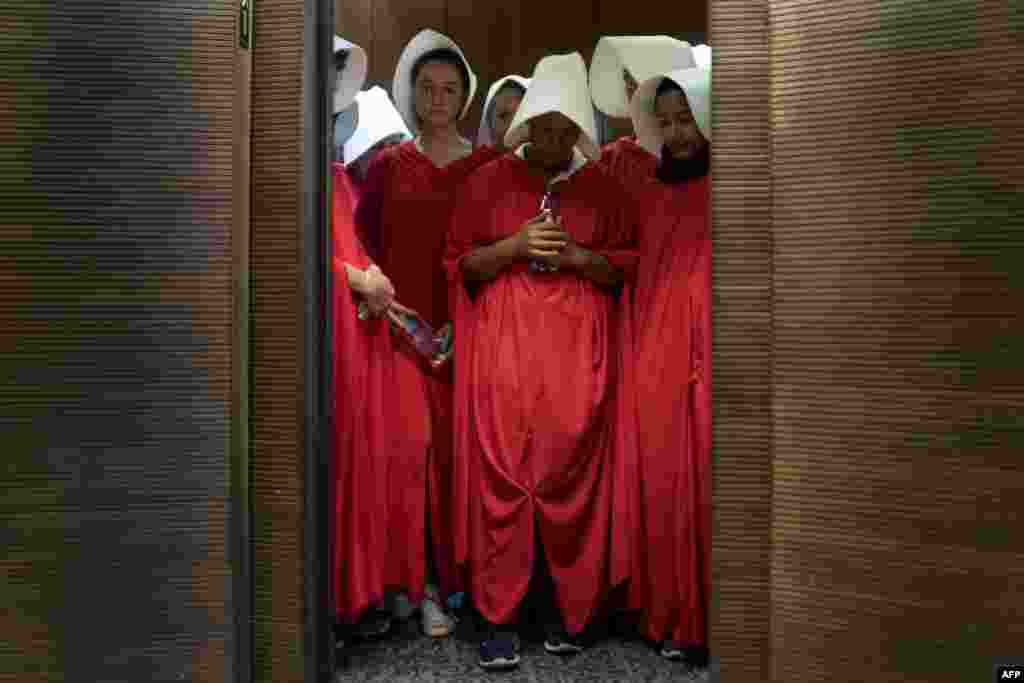 Women dressed as characters from the novel-turned-TV series &quot;The Handmaid&#39;s Tale&quot; stand in an elevator at the Hart Senate Office Building as Supreme Court nominee Brett Kavanaugh starts the first day of his confirmation hearing in front of the U.S. Senate on Capitol Hill in Washington, D.C.