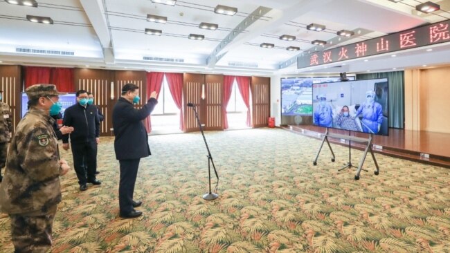 戴着口罩的中国国家主席习近平视察火神山医院时通过视频向新冠病毒感染者和医护人员招手。（2020年3月10日）