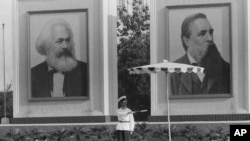 歷史照片：在馬克思和恩格斯的巨幅畫像下，警察在北京天安門廣場附近指揮交通。 (1972年9月1日)