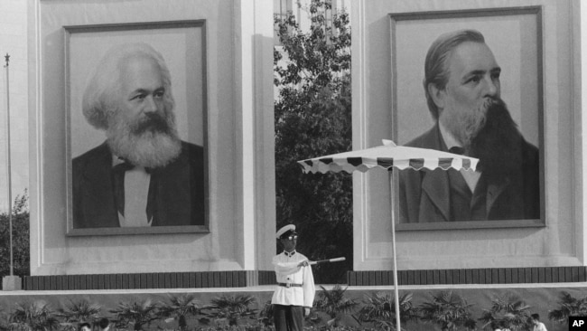历史照片：在马克思和恩格斯的巨幅画像下，警察在北京天安门广场附近指挥交通。(1972年9月1日)