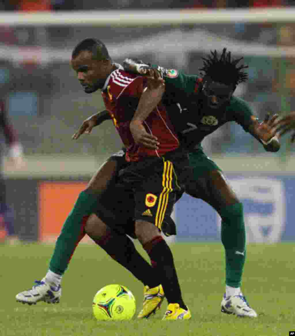 Flavio Amado e Roumba Florent, do Burkina Faso, empenhados numa jogada durante o primeiro jogo das Palancas Negras, no CAN 2012, no Estádio de Malabo, a 22 de Janeiro