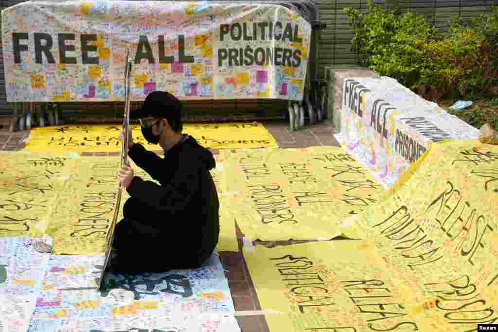 A supporter of pro-democracy activists holds a sign outside West Kowloon Magistrates&#39; Courts where others queue up for a court hearing over charges related to national security, in Hong Kong, China.