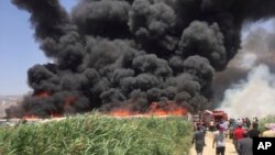 This photo provided by the Qab Elias Emergency Services, shows smoke billows from a Syrian refugee camp in Qab Elias, a village in the Bekaa Valley, Lebanon, July 2, 2017.