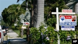 "For Sale" signs line the front yards of several houses in a Hollywood, Florida neighborhood (file)