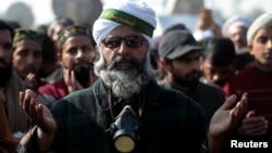 Supporters of the Tehreek-e-Labbaik Pakistan Islamist political party say a prayer after their leader Khadim Hussain Rizvi announced an end to their protest in Islamabad, Pakistan, Nov. 27, 2017. The party has called off new protests following an agreement with the government.