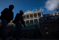 FILE - People walk past Palais Coburg, where closed-door nuclear talks take place in Vienna, Austria, Dec. 17, 2021.