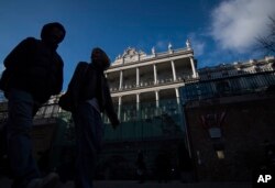 FILE - People walk past Palais Coburg, where closed-door nuclear talks take place in Vienna, Austria, Dec. 17, 2021.