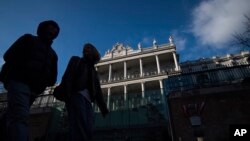 FILE - People walk past Palais Coburg, where closed-door nuclear talks take place in Vienna, Austria, Dec. 17, 2021.