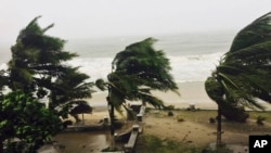 Trees are lashed by strong winds in Sambava, Madagascar, March 7, 2017 as heavy rains and strong winds from a cyclone hit northeast Madagascar, raising concerns about flooding and landslides. 