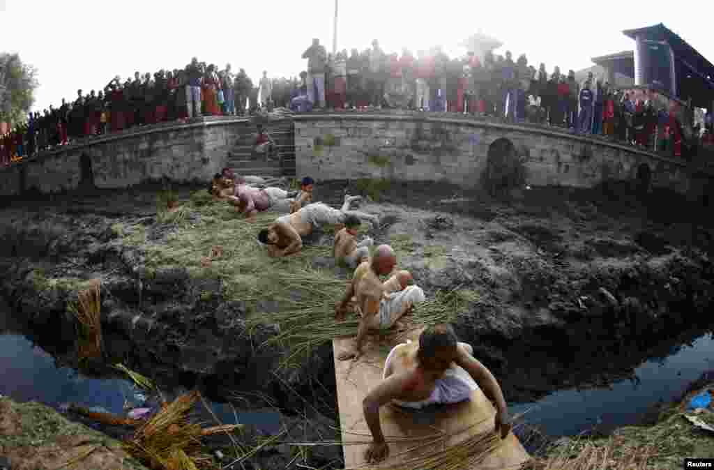 Devotees offer prayer by rolling on the street during the final day of the month-long Swasthani festival at Bhaktapur near Kathmandu, Nepal.