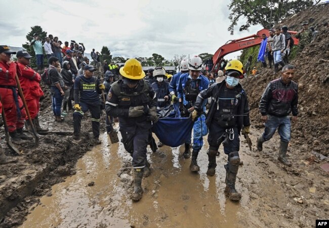 Rescue workers carry a corpse after a landslide in Rosas, Cauca department, in southwestern Colombia, April 21, 2019.