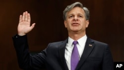 ທ່ານ Christopher Wray ສາບານໂຕ ຢູ່ທີ່ລັດຖະສະພາ ສະຫະລັດ ຫຼື Capitol Hill ໃນນະຄອນຫຼວງ ວໍຊິງຕັນ, ວັນທີ 12 ກໍລະກົດ 2017, ກ່ອນໜ້າການໃຫ້ປາກຄຳ ໃນການພິຈາລະນາ ຮັບເອົາການແຕ່ງຕັ້ງ ຕໍ່ໜ້າ ຄະນະກຳມະການ ຕຸລາການ ຂອງສະພາສູງ. 