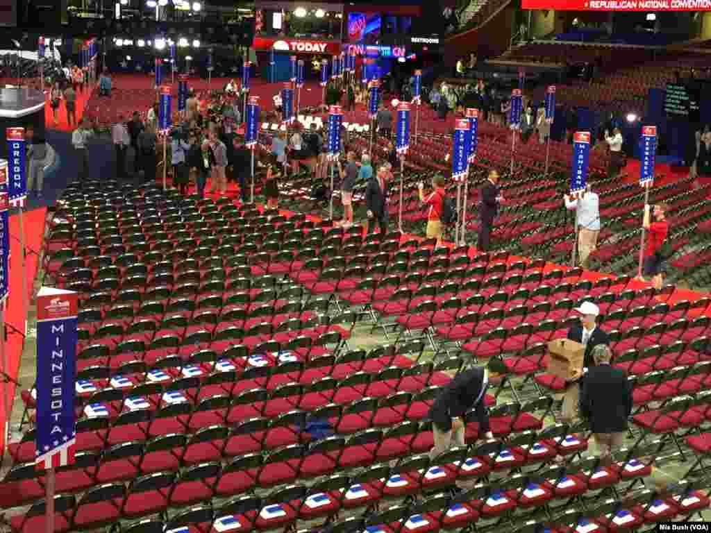 Convention workers leave a booklet that lists the convention delegates and a nightly schedule on the delegates' seats at Quicken Loans Arena before the Republican convention begins, in Cleveland, July 19, 2016.