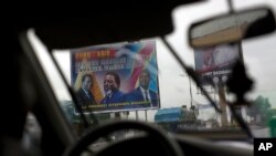 A poster featuring Congo's current President Joseph Kabila with ruling party candidate and former interior minister Emmanuel Ramazani Shadary is displayed on the road leading to the airport in Kinshasa, Democratic Republic of the Congo, Dec. 17, 2018. 