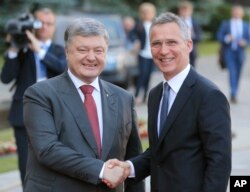 Ukrainian President Petro Poroshenko, left, and NATO Secretary General Jens Stoltenberg, shakes hands during a meeting in Kyiv, July. 10, 2017.