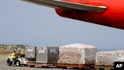 FILE - Workers unload medical supplies from a Chinese airplane at the Simon Bolivar International Airport in Maiquetia, near Caracas, Venezuela, March 29, 2019. 