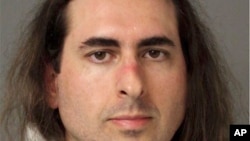 In this June 28 2018 photo released by the Anne Arundel Police, Jarrod Warren Ramos poses for a photo, in Annapolis, Maryland. First-degree murder charges were filed Friday against Ramos who police said targeted Maryland's capital newspaper, shooting his way into the newsroom and killing four journalists and a staffer before officers swiftly arrested him. 