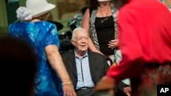 FILE - Former president Jimmy Carter sits to pose for photos after teaching Sunday School class at Maranatha Baptist Church in his hometown Aug. 23, 2015, in Plains, Georgia.
