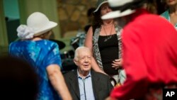 Former president Jimmy Carter, sits to pose for photos after teaching Sunday School class at Maranatha Baptist Church in his hometown Aug. 23, 2015, in Plains, Georgia.
