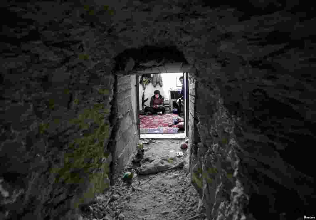 A Free Syrian Army fighter is seen through a tunnel in eastern Afrin, Syria.