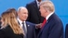 FILE - President Donald Trump, right, walks past Russia's President Vladimir Putin, left, as they gather for a group photo at the start of the G-20 summit in Buenos Aires, Argentina, Nov. 30, 2018.