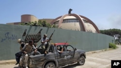 Rebel fighters seen inside the main Moammar Gadhafi compound in Bab al-Aziziya in Tripoli, Libya, August 24, 2011