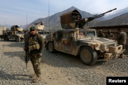 FILE - Afghan National Army soldiers keep watch at the Forward Base in Nari district near the army outpost in Kunar province, in this Feb. 24, 2014 file picture.