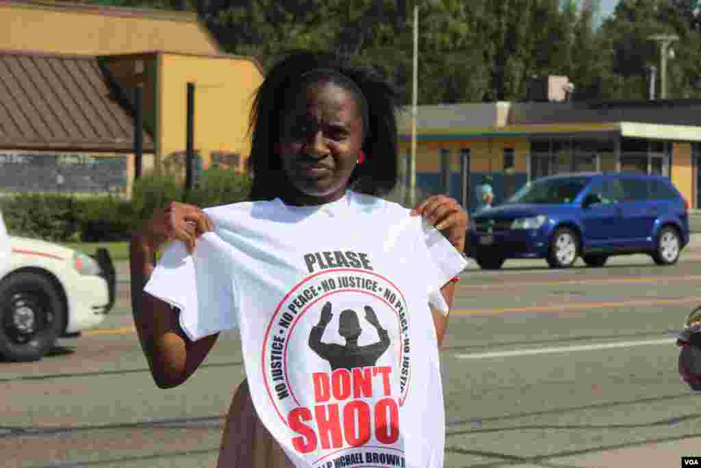 A woman holds up a tee shirt referring to the shooting of unarmed African American teenager Michael Brown, Ferguson, Missouri, Aug, 24, 2014. (Gesell Tobias, VOA)