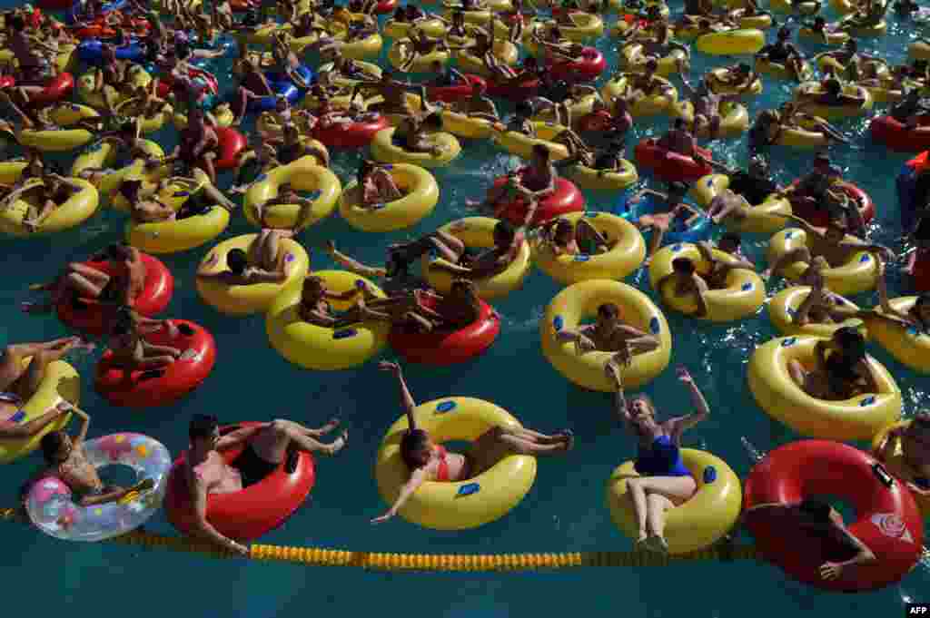 People cool off in a pool at an aqua park in Minsk, Belarus, as temperatures there reach 30° C (86° F).