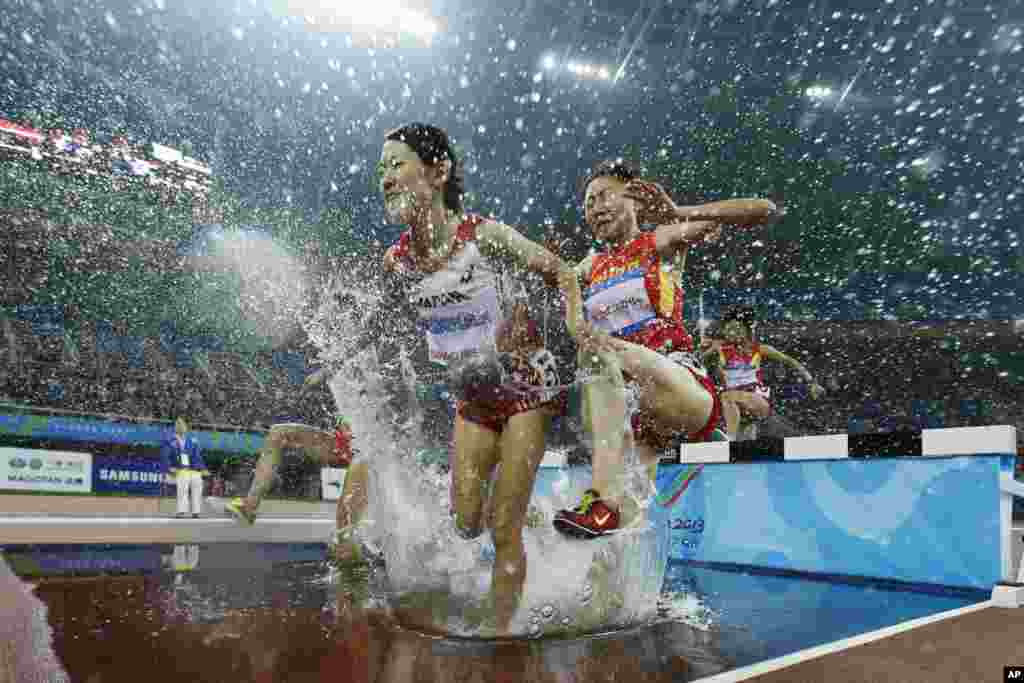 Japan's Misaki Sango, front left, China's Li Zhenzhu, front right, Yin Anna, back left, and North Korea's Pak Kum Hyang, back right, compete in women's 3000-meter steeplechase at the sixth East Asian Games in Tianjin, China.