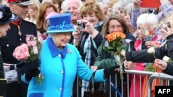 Ratu Inggris, Elizabeth II menyalami warga yang menyambutnya (foto: dok). 