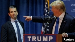 FILE - Then U.S. Republican presidential candidate Donald Trump welcomes his son Donald Trump Jr. to the stage at a campaign event in Manchester, New Hampshire Nov. 11, 2015. 