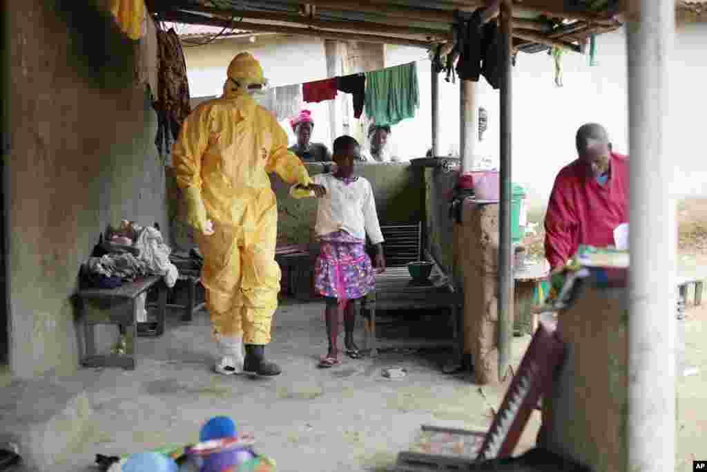 Nowa Paye, 9, is taken to an ambulance after showing signs of Ebola infection in Freeman Reserve, about 30 miles north of Monrovia, Liberia, Sept. 30, 2014. 