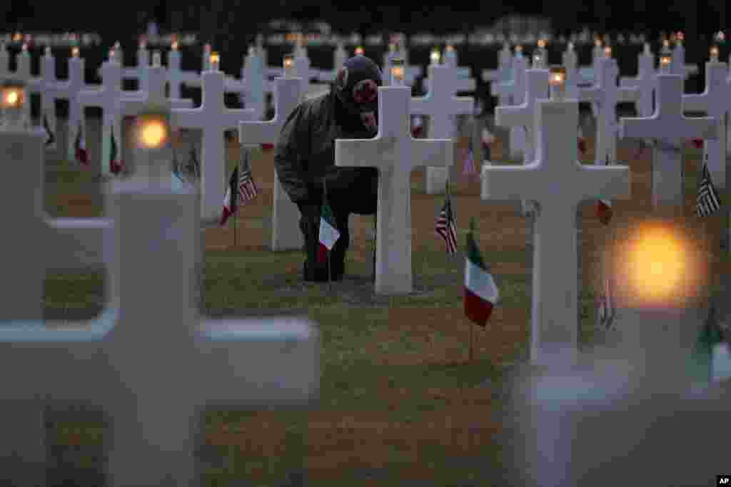 A re-enactor wearing U.S. World War II clothing kneels during a ceremony at the Sicily-Rome American Cemetery to commemorate the landing of allied forces on the shores of Anzio and Nettuno, in Nettuno, Italy.