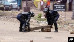 Des éléments de la police débarrassent la rue des barricades lors d'une manifestation à Kinshasa, 19 septembre 2016.