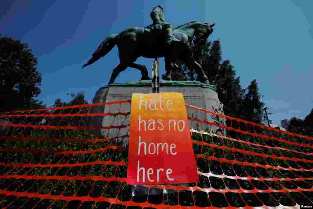 آویختن پارچه ای با شعار تنفر در اینجا خانه ای ندارد بر مجسمه ژنرال رابرت لی در سالگرد تظاهرات شارلوتزویل ایالت ویرجینیای آمریکا