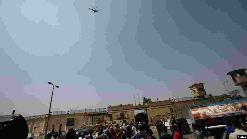 Supporters of deposed Egyptian president Hosni Mubarak gesture as the helicopter carrying him leaves Tora prison, Cairo, August 22, 2013. 