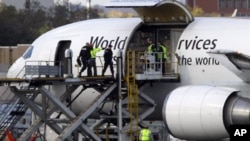 Investigators board a United Parcel Service jet isolated on a runway at Philadelphia International Airport in Philadelphia, Friday, Oct. 29, 2010.