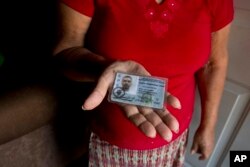 In this Nov. 3, 2018 photo, Haydee Posadas shows the driver's license her son Wilmer Gerardo Nunez was carrying when he was blindfolded and shot dead on his journey north, at her home in Ciudad Planeta neighborhood of San Pedro Sula, Honduras.