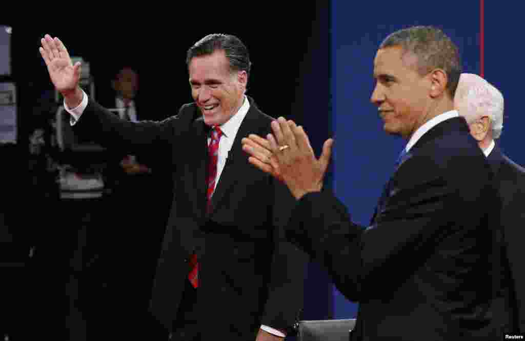 صدر براک اوباما اور ریپبلکن کے صدارتی امیدوار مٹ رومنی شرکاء کا ہاتھ ہلا کر جواب دے رہے ہیں