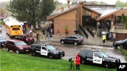 Polisi dan lainnya berjaga di luar sebuah pusat rekreasi di pinggiran Denver Highlands Ranch, Colorado, tempat para siswa berkumpul kembali dengan orang tua mereka, pasca penembakan di STEM School Highlands Ranch, Selasa, 7 Mei 2019.