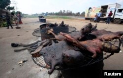 People walk near dried bushmeat near Yamoussoukro highway in Ivory Coast on March 29, 2014.